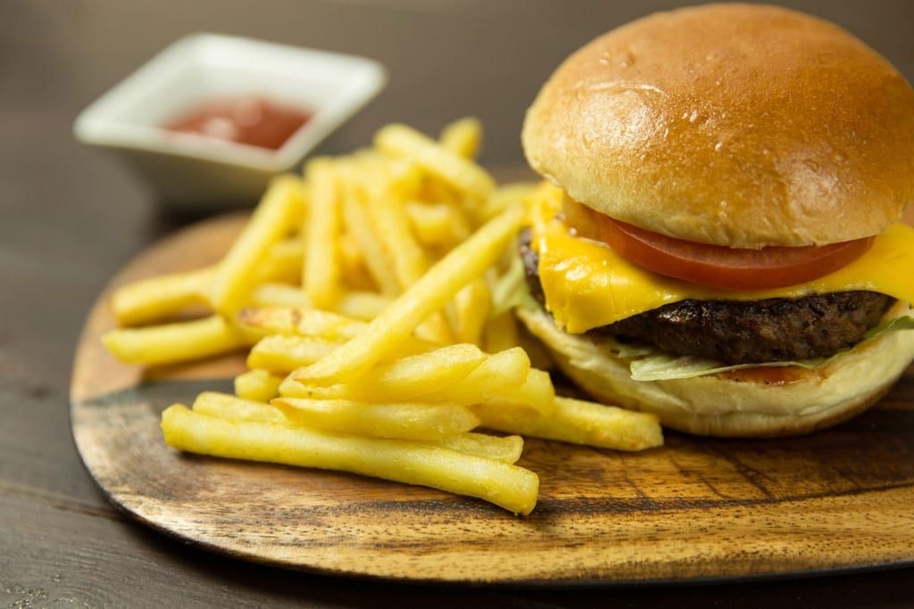 A cheeseburger with a pile of fries