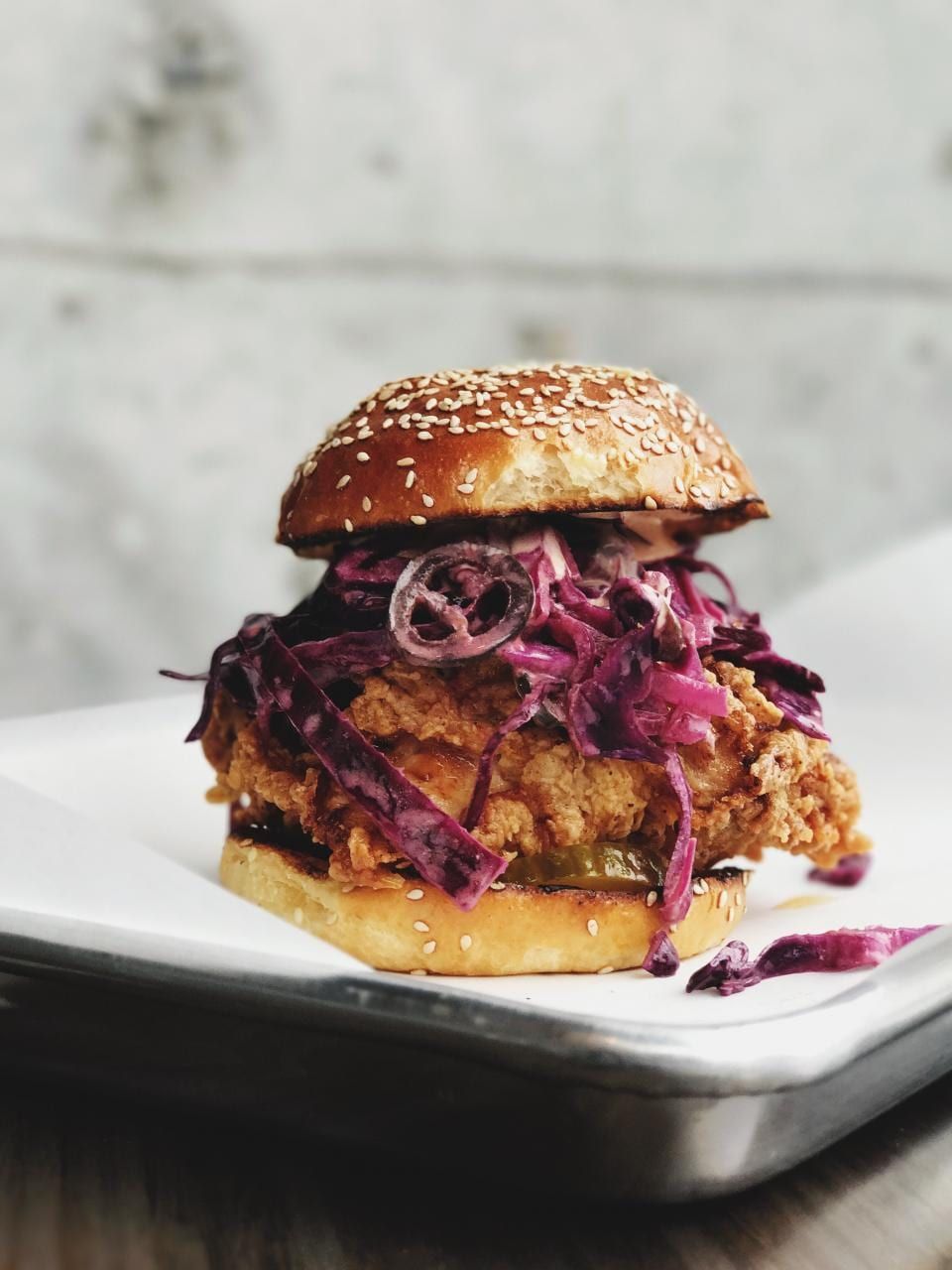 A crispy chicken sandwich piled with purple slaw