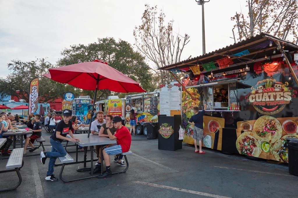 Food trucks and picnic tables at an outdoor food rally